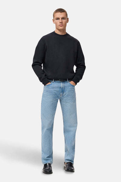 Blauwe trui van MANGO, gedragen met een verbleekte spijkerbroek en zwarte leren schoenen.