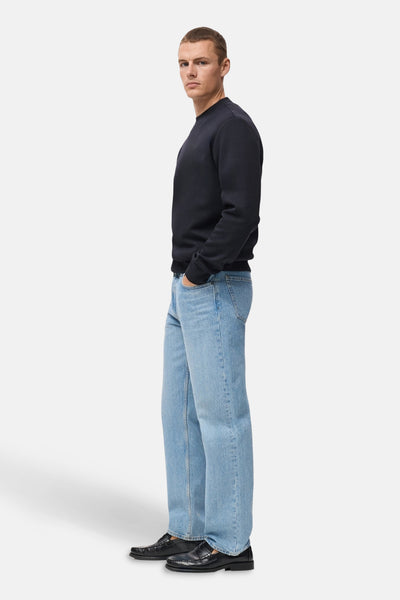 Blauwe sweater van MANGO, gedragen met een casual spijkerbroek en zwarte loafers, zijaanzicht.
