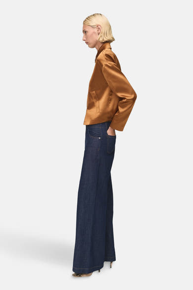 Gilet brun de MANGO, porté avec un jean ample foncé et des escarpins à motif serpent, vue de côté.