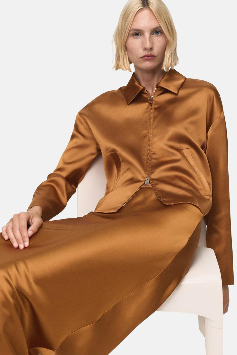 Gilet brun de MANGO, style décontracté avec fermeture éclair sur un ensemble satiné couleur bronze.