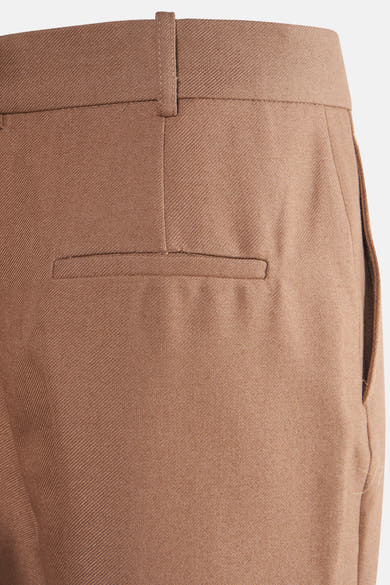 Pantalon beige de MANGO avec poche arrière passepoilée et passants de ceinture.