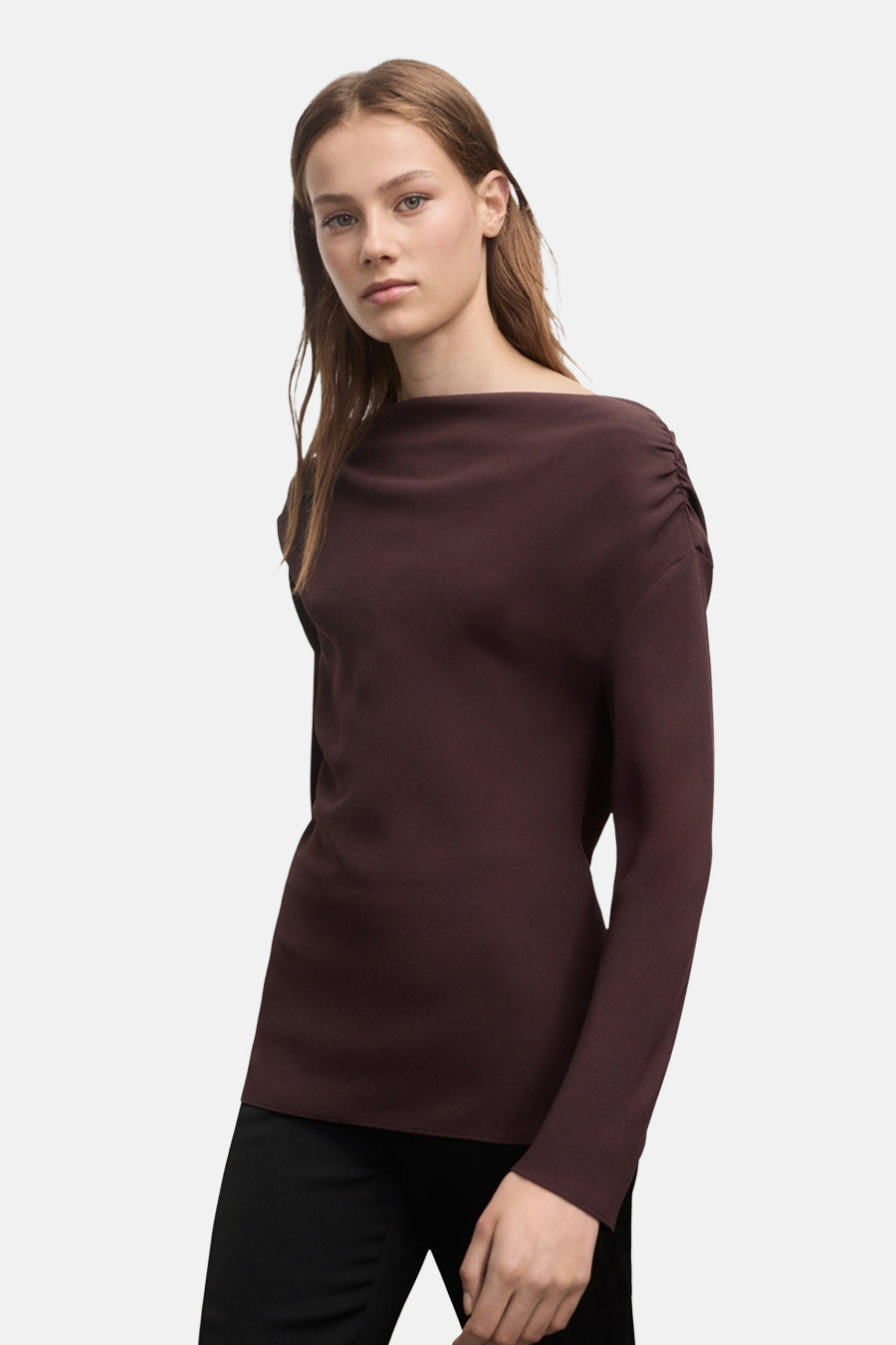 Bruine blouse met lange mouwen van MANGO, van achteren gezien, gedragen met een zwarte uitlopende broek.