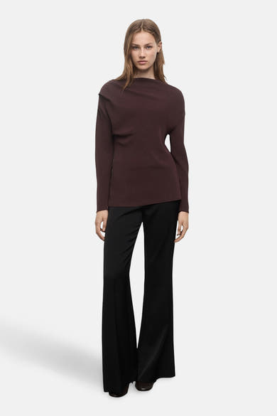 Blouse à manches longues brun de MANGO, portée avec un pantalon noir à jambe évasée.