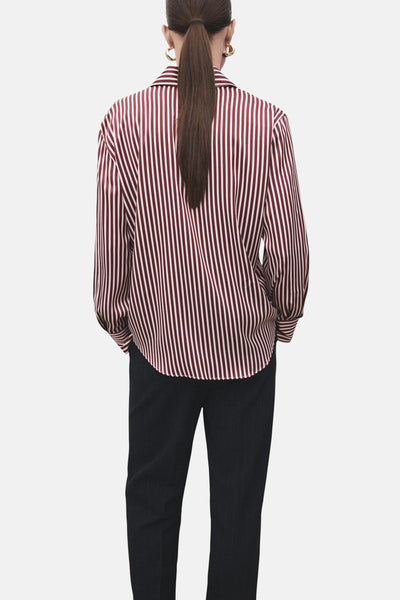 Chemise à manches longues rouge rayée de MANGO, vue de dos, portée avec un pantalon noir.
