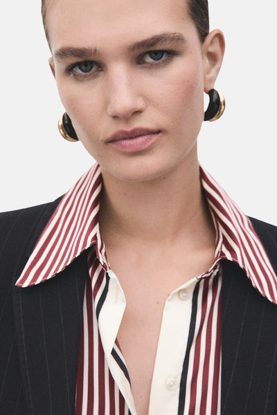 Rode gestreepte blouse van MANGO, open gedragen onder een dun gestreepte blazer en oorbellen.