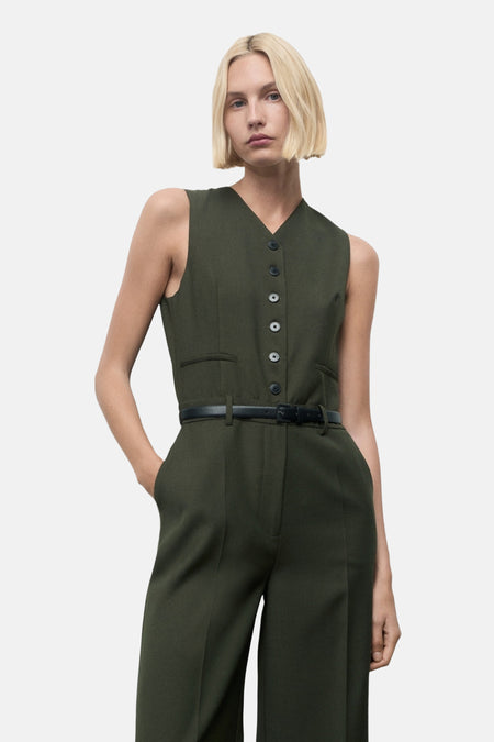 Combinaison kaki par MANGO, avec un gilet boutonné et une ceinture noire fine à la taille.