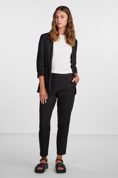 Blazer noir by PIECES, porté sur un t-shirt blanc et un pantalon noir à motif discret.