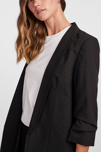Blazer noir de PIECES®, porté sur un t-shirt blanc, avec des manches retroussées.