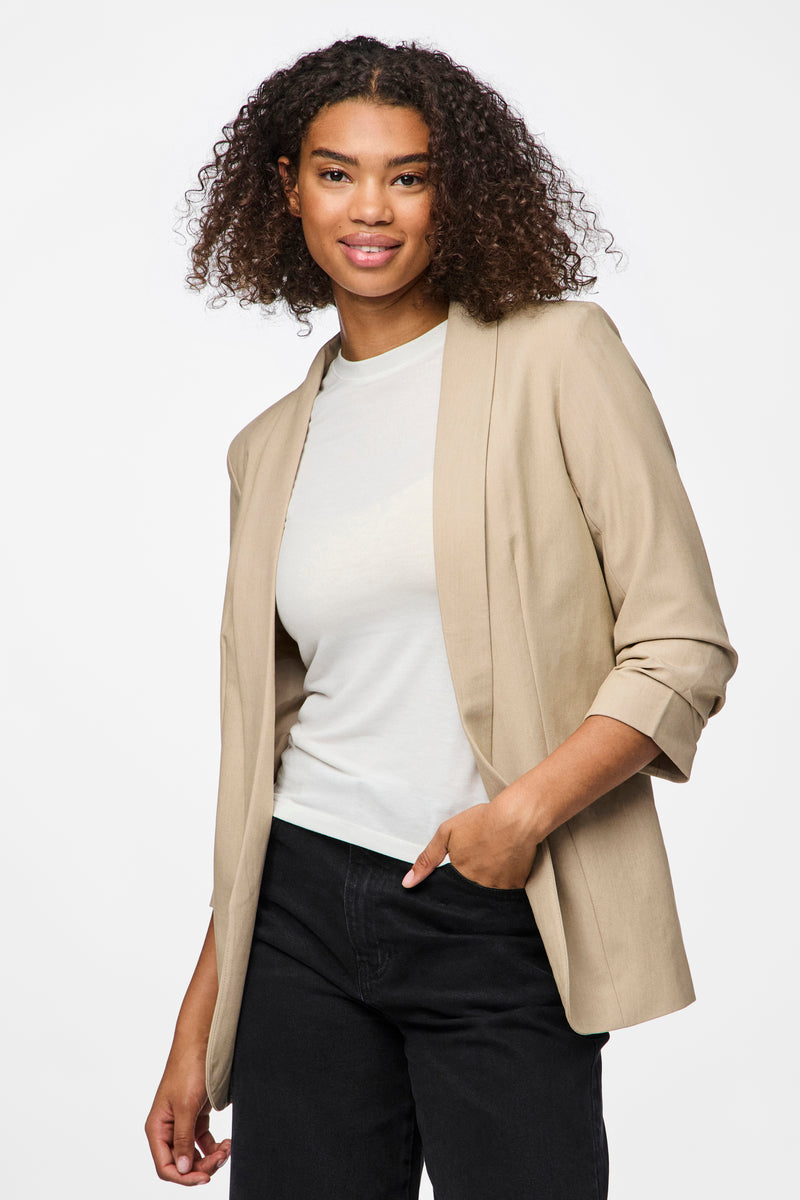 Blazer beige de PIECES®, porté sur un t-shirt blanc et un jean noir.