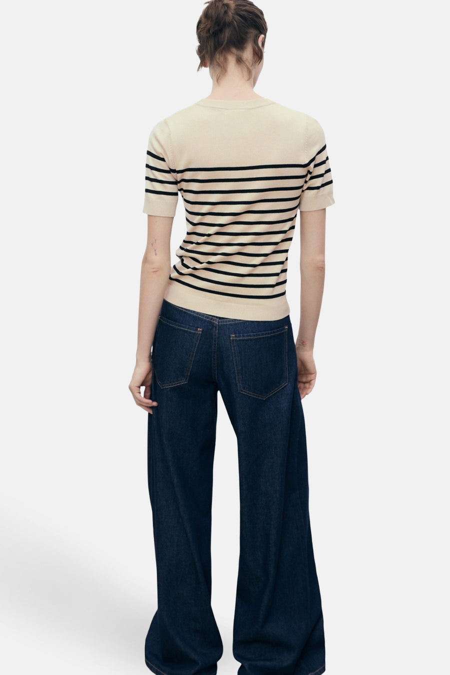 Beige T-shirt met zwarte strepen van MANGO, gedragen met een donkerblauwe wijde jeans, achterkant.