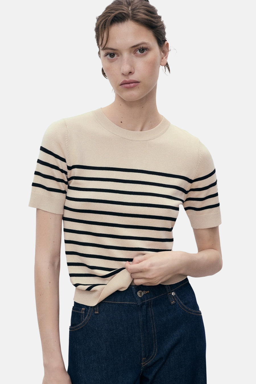 Beige T-shirt met zwarte strepen van MANGO, gedragen met een donkere jeans.