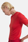 Rood T-shirt met korte mouwen van MANGO, gedragen met zilveren oorbellen en een bijpassende broek.