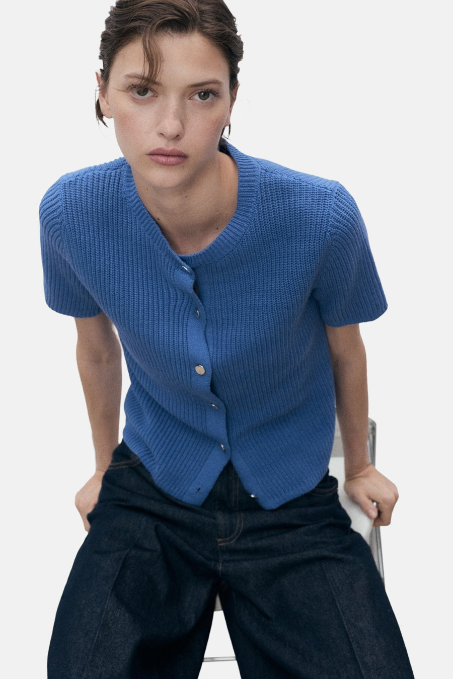 Blauwe geribbelde gebreide cardigan van MANGO, gedragen met een wijde spijkerbroek.