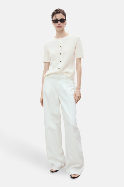 Witte MANGO-cardigan met korte mouwen, gedragen met een wijde witte broek en een zonnebril.