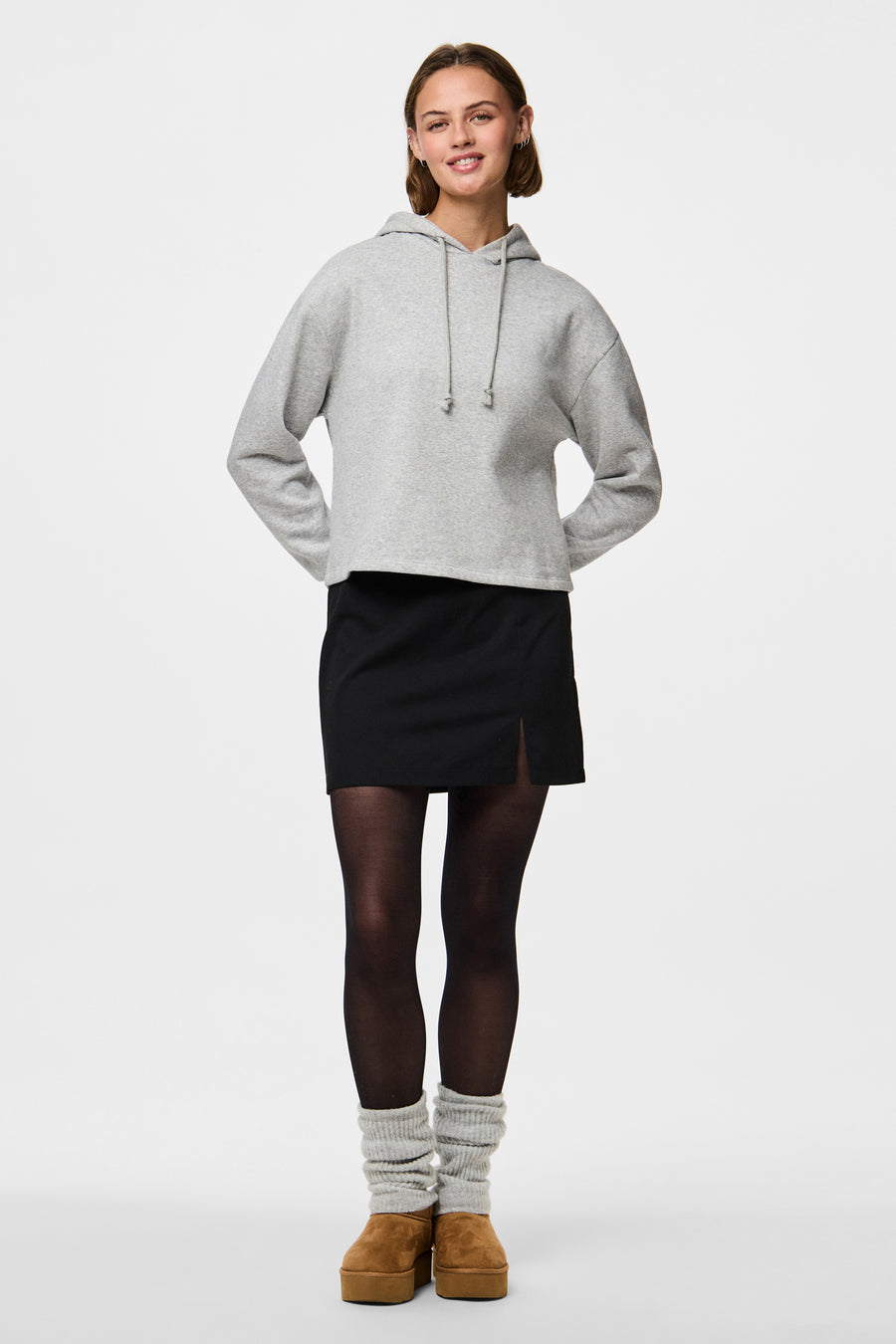 Zwarte panty's van PIECES, gedragen met een zwarte rok en bruine sleehakken.