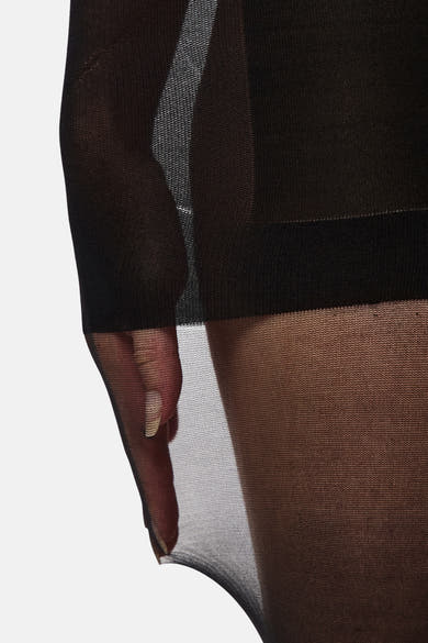 Zwarte doorschijnende panty van PIECES, met een transparant effect en een zichtbare hand.