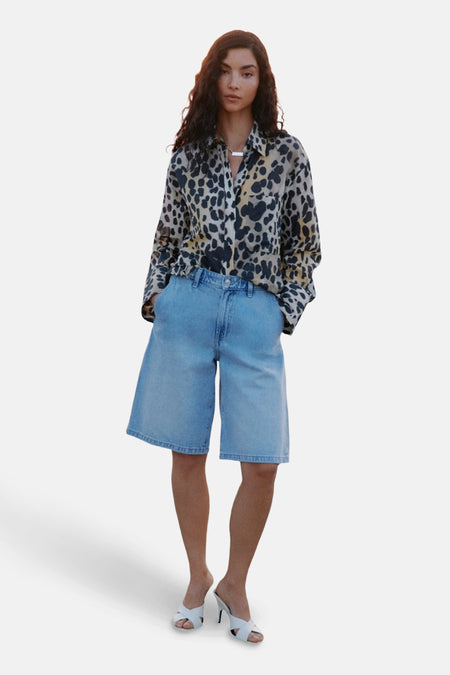 Chemisier à manches longues multicolore de MANGO, avec un motif animalier et porté avec un short en jean.
