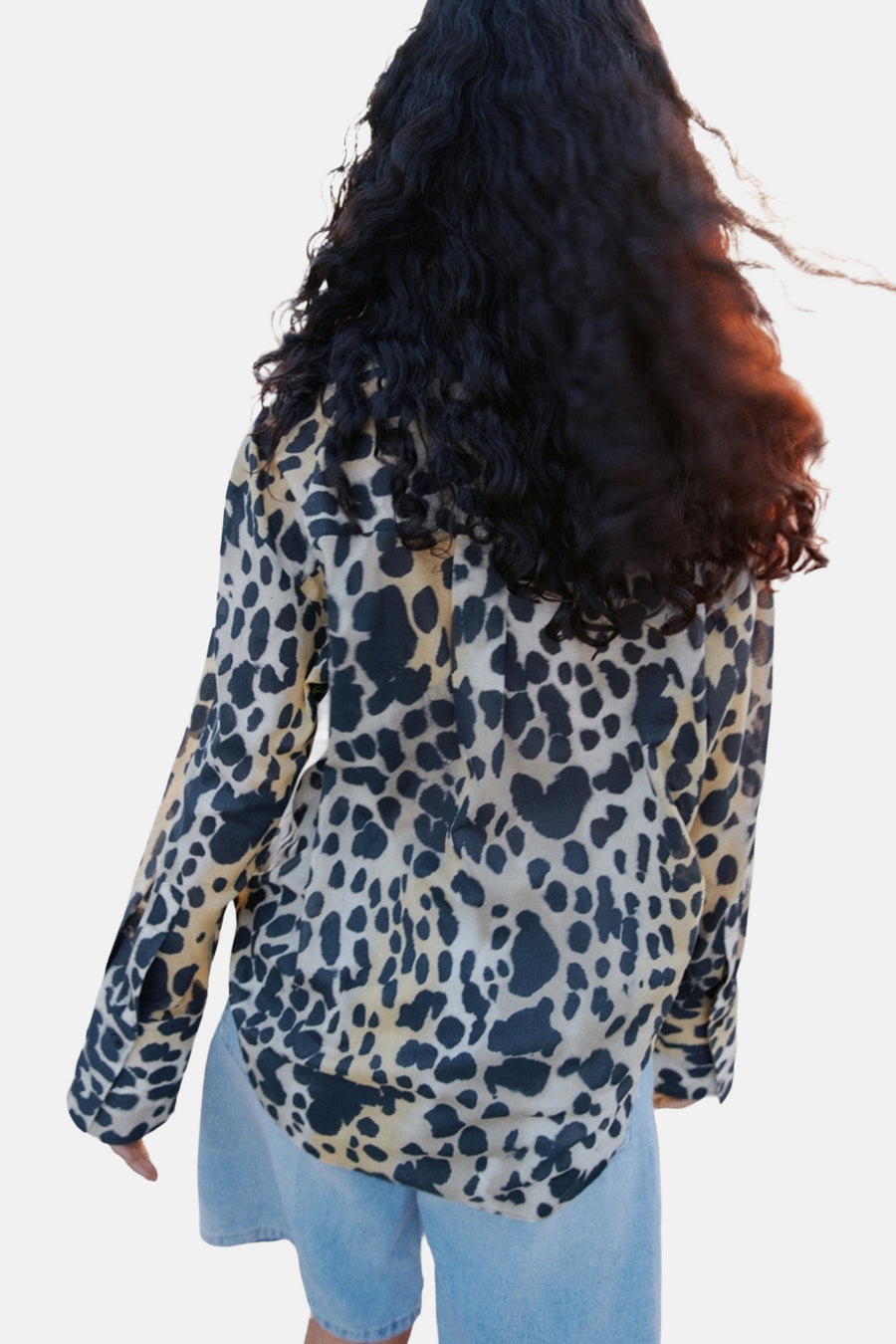 Chemisier à manches longues imprimé animalier, de MANGO, porté avec un short en jean bleu clair.