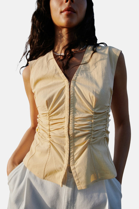 Gele mouwloze blouse van MANGO met centraal ruchedetail en V-hals.