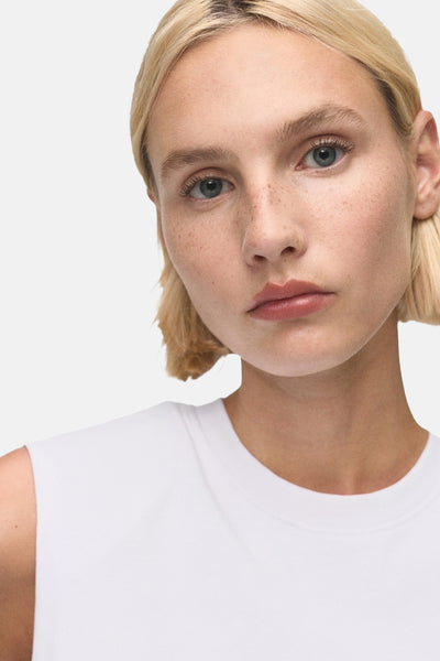 Wit mouwloos topje van MANGO, gedragen met kort blond haar.