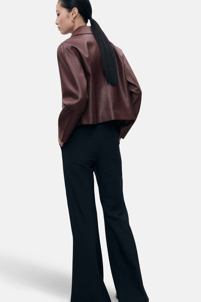 Veste courte bordeaux de MANGO, portée avec un pantalon noir ample, vue de dos.
