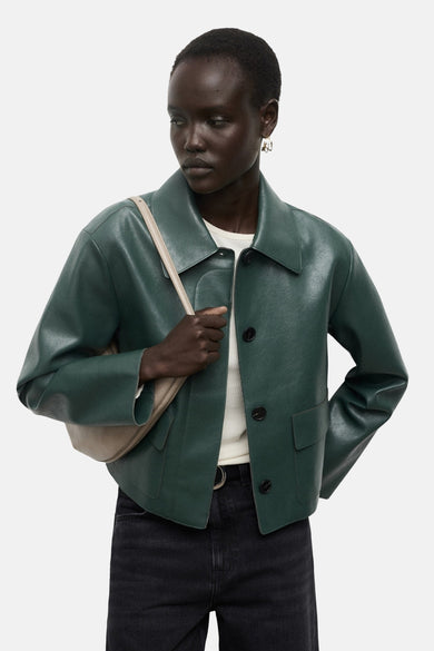Korte groene jas van MANGO, met een gestructureerde pasvorm en gedragen met een wijde zwarte jeans.