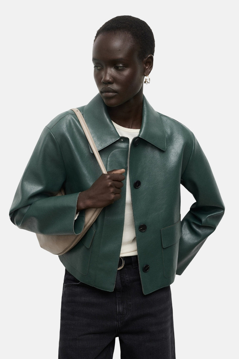 Korte groene jas van MANGO, met een gestructureerde pasvorm en gedragen met een wijde zwarte jeans.