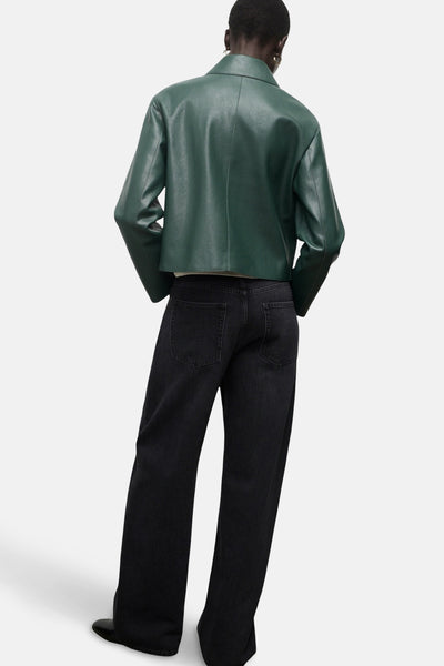 Veste courte verte de MANGO, avec une coupe structurée et portée avec un jean noir ample.