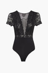 Body noir en dentelle par PIECES®, avec manches courtes et décolleté en V transparent.
