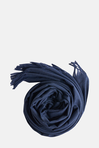 Écharpe bleue enroulée de MANGO, avec des franges effilochées sur les extrémités.