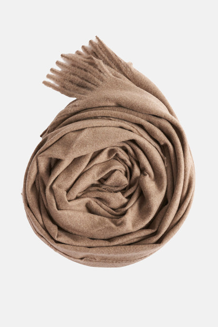 Écharpe beige de MANGO, enroulée sur elle-même, avec des franges visibles.
