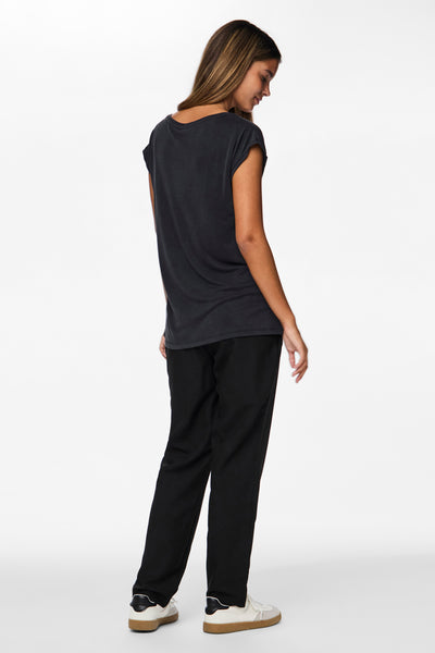 T-shirt noir de PIECES®, porté avec un pantalon noir et des baskets blanches.