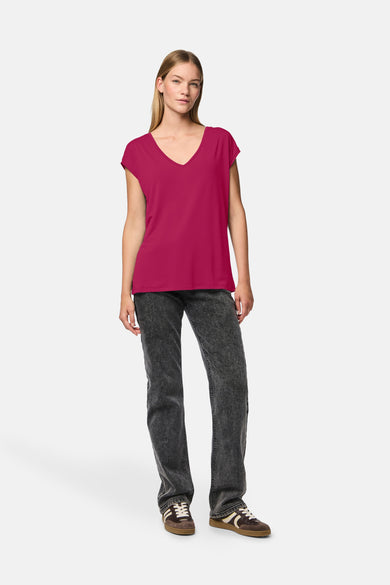 Rosa korte mouw T-shirt van PIECES®, gedragen met een gebleekte jeans enbrubruine sneakers.