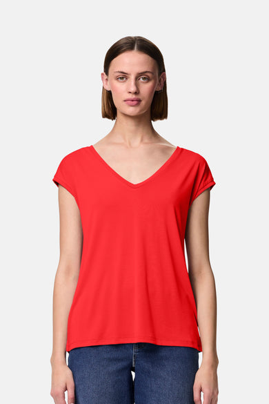 Rood t-shirt met korte mouwen van PIECES®, gedragen met een brede blauwe jeans en zwarte platformschoenen.