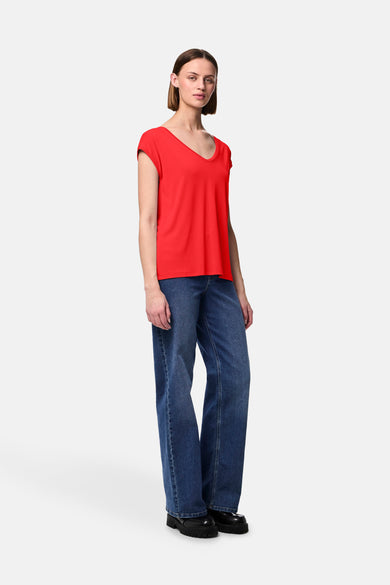 T-shirt à manches courtes rouge de PIECES®, porté avec un jean ample bleu et des chaussures noires à plateforme.
