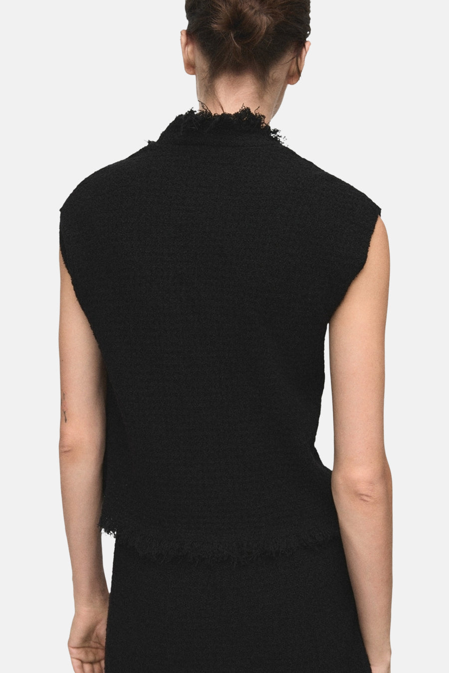 Débardeur noir en tweed de MANGO, avec un col montant et ourlet frangé, vue de dos.