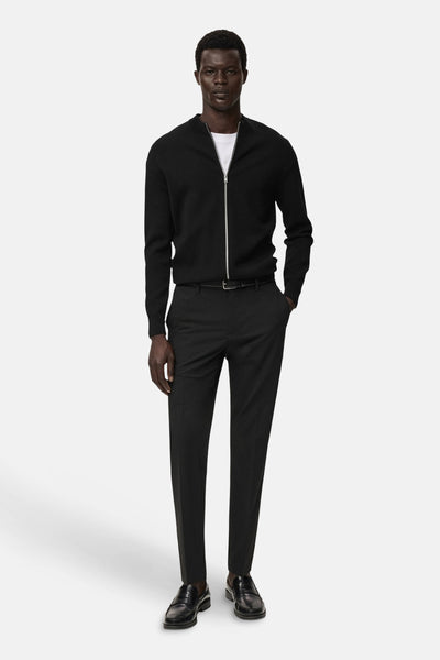 Zwarte MANGO bodywarmer, gedragen met een wit T-shirt en een donkere pantalon.