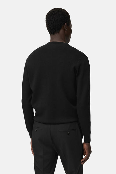 Zwarte MANGO bodywarmer, gedragen met een zwarte broek, achterzijde.