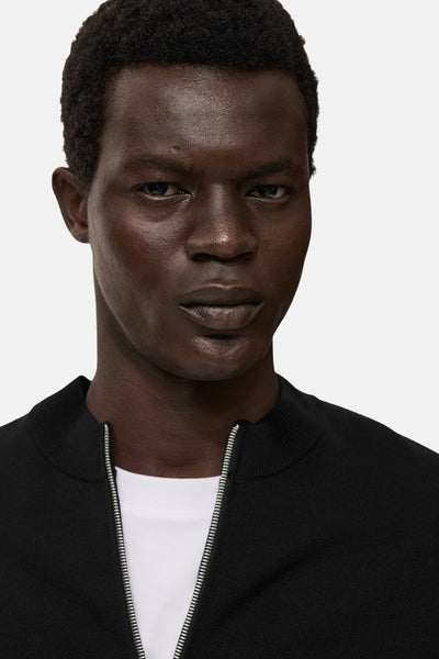 Zwarte MANGO bodywarmer, met zilveren ritssluiting en een witte T-shirt eronder zichtbaar.
