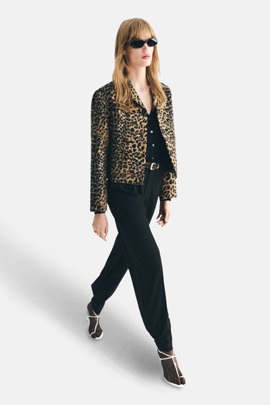 Blazer marron à motif léopard, de MANGO, porté avec un pantalon noir et des chaussures à talons.