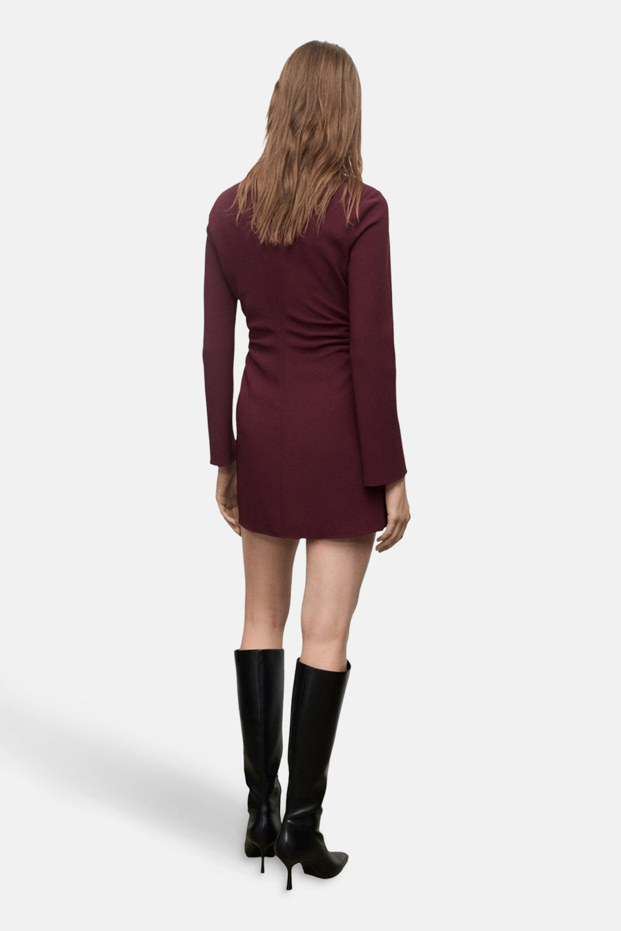 Robe bordeaux à manches longues de MANGO, vue de dos, portée avec des bottes hautes noires.
