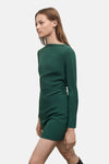 Groene jurk met lange mouwen van MANGO, gedragen met hoge zwarte laarzen met hak.