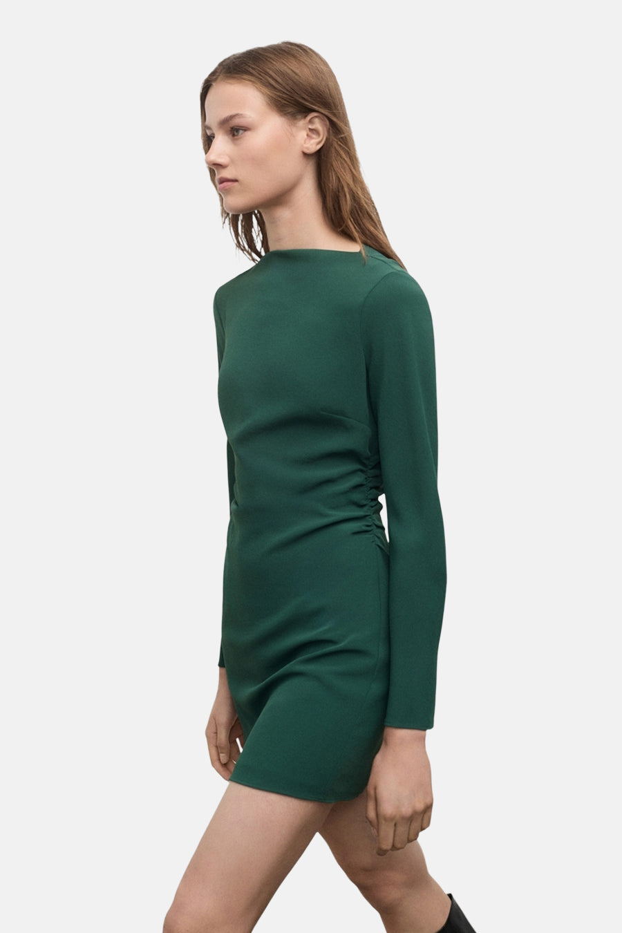 Groene jurk met lange mouwen van MANGO, gedragen met hoge zwarte laarzen met hak.