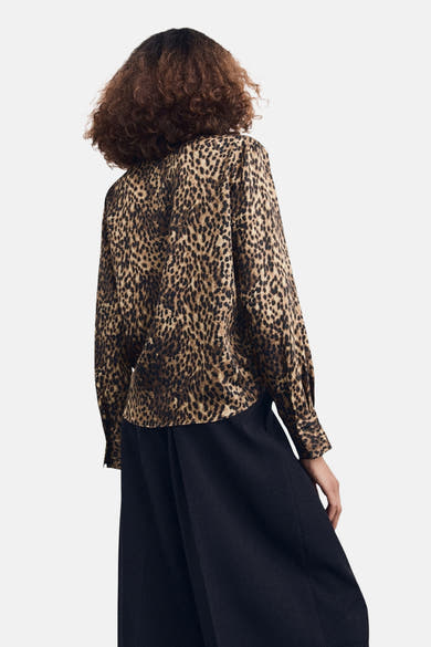 Chemisier à manches longues multicolore de MANGO, avec motif léopard et pantalon noir.
