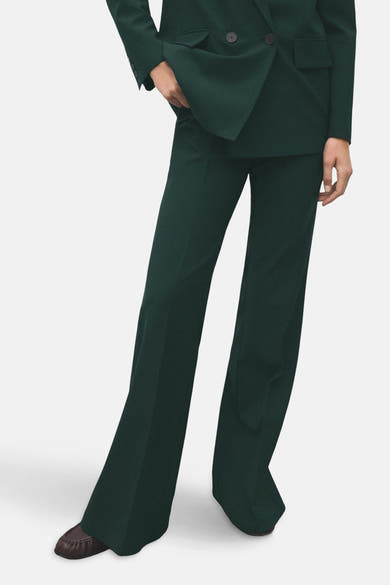 Groene broek van MANGO, wijd uitlopend model en hoge taille, gedragen met een bijpassende blazer.