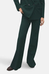Groene broek van MANGO, wijd uitlopend model en hoge taille, gedragen met een bijpassende blazer.