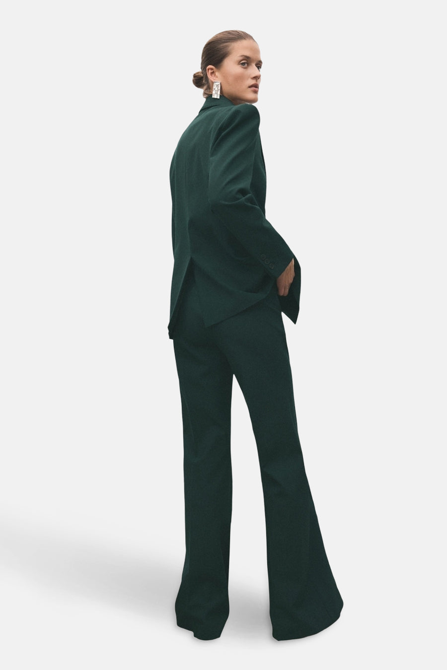 Pantalon vert de MANGO, coupe évasée et taille haute, porté avec un blazer assorti.