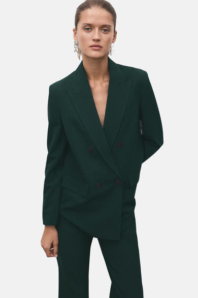 Groene broek van MANGO, gedragen met een bijpassende blazer, elegante pakstijl.