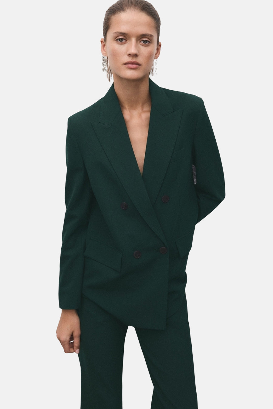 Groene broek van MANGO, gedragen met een bijpassende blazer, elegante pakstijl.