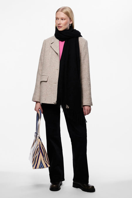 Zwarte sjaal van PIECES®, gedragen met een beige blazer, een roze trui en een zwarte broek.